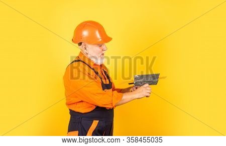He Needs Little Break. Plasterer In Working Uniform Plastering. Man With Spatula. Process Of Applyin