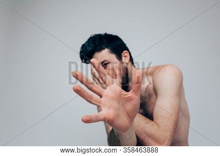Young Man Isolated Over Background. Posing On Camera Alone And With Naked Chest. Show Hand. Mental D