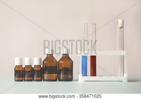 Bottles Of Medicine Lined Up In A Row. Beakers With Chemicals. Chemical Experiments, Vaccines, Blood