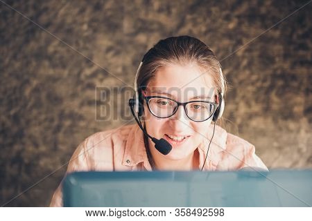 Young Woman In Headphones Speaking Looking At Laptop. Work From Home. Online Work.