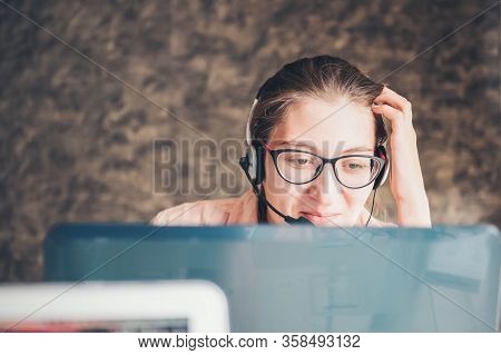 Young Woman In Headphones Speaking Looking At Laptop. Work From Home. Online Work.