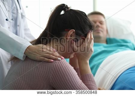 Woman In Clinic Crying Near Man In Hospital Bed. Unique Care System For Severe Patients. Care And Co