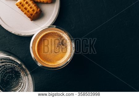One Portion Of Espresso In Glass Transparent Cups, Bisuits And Water On A Dark Stone Background, Cop