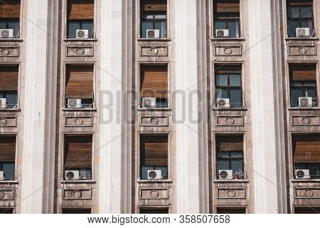 The Exterior Of An Old Soviet Era Style Building With Window Air Conditioning Machines.