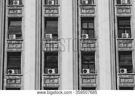 The Exterior Of An Old Soviet Era Style Building With Window Air Conditioning Machines.