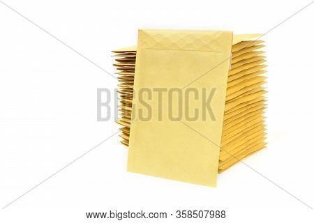 Yellow Envelope Leaning On A Huge Stack Of Bubble Mailers.