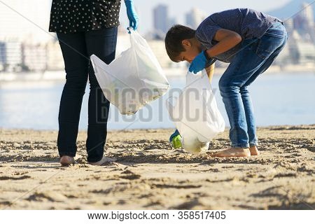 Cleaning City Beach From Plastic Trash. Volunteers Picking Up Plastic Bottle. Soft Drinks Cans Trash