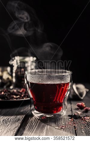 Cup Of Freshly Brewed Red Karkade Tea, Rose Tea Ceremony, Dark Moody.hot Water Is Poured From The Ke