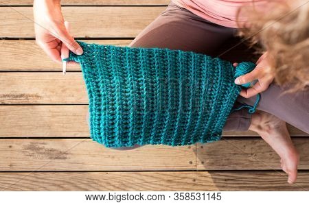 Woman Crochets Sitting In Bed, Needlework During Quarantine, The Girl Knits From Thick Blue Yarn, Fe