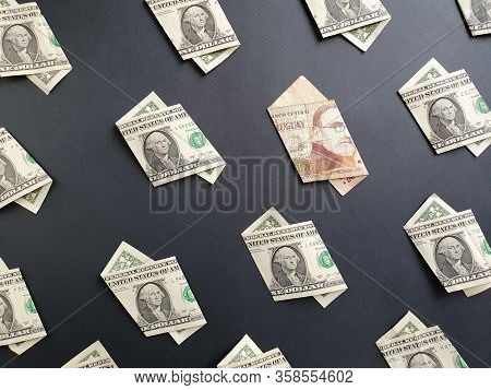 American One Dollar Bills And Uruguayan Banknote Of 200 Pesos On The Black Background