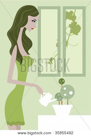 一个女人在绿色的裙子给植物浇水的侧视图