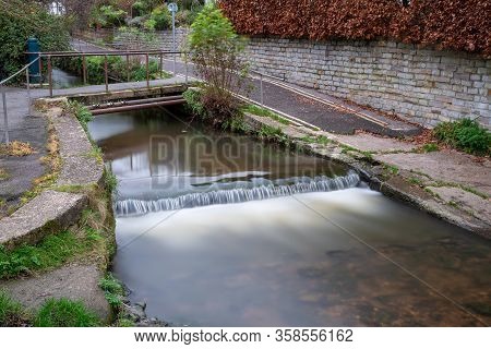 Long Exposure Of A Watefall On The River Lim Walkway At Lyme Regis In Dorset.