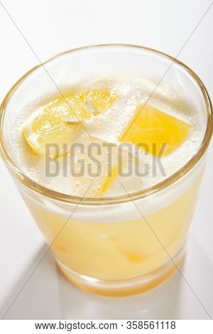 Lemon pie cocktail close up. Alcohol strong drink in glass side view. Beverage with vodka and lemon juice in drinkware. Cocktail portion with crushed ice and vanilla flavor in glassware
