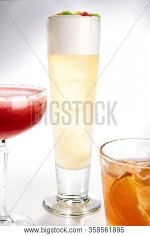 Breakfast fizz cocktail close up. Alcohol strong drink in glass side view. Beverage with gin, egg white and fruits in drinkware. Cocktail portion decorated with berries in glassware