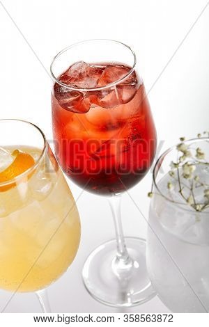 Rose Spritz cocktail. Alcohol soft drinks in glasses side view. Refreshment beverage with rose lemonade in drinkware. Exotic summer beach cocktail portions with crushed ice in glassware