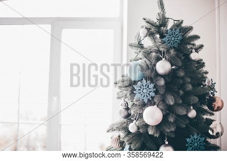 Daylight In Room. Christmas Tree With Decoration Stand In White Space. Prepapring For Celebration. B