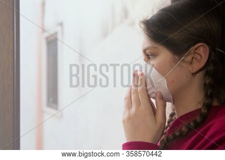 Young Girl In Home Isolation, During Quarantine Is Wearing Protective Face Mask For Stave Off Preadi