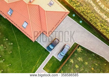 Top Down Aerial View Of A Private House With Red Tiled Roof And Spacious Yard With Parked Two New Ca