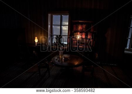 A Realistic Dollhouse Living Room With Furniture And Window At Night. Artwork Table Decoration With