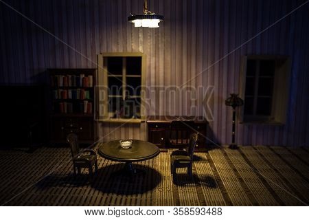 A Realistic Dollhouse Living Room With Furniture And Window At Night. Artwork Table Decoration With
