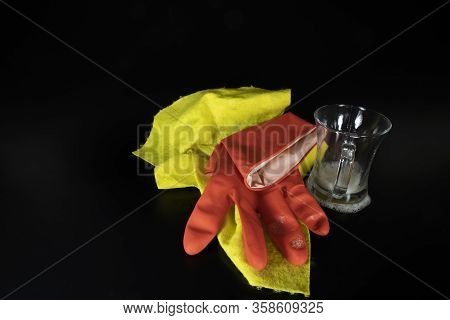 Scouring Sponge Foaming Gloves And Yellow Cleaning Cloth. In Black Background. Close Up.
