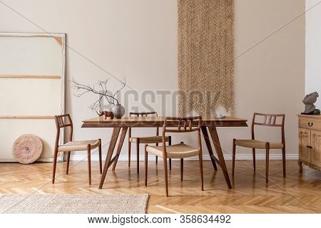 Stylish And Beige Interior Of Dining Room With Design Wooden Table And Chairs, Raw Tree Branch In Va