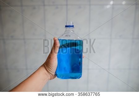 Shallow Depth Of Field Image (selective Focus) With The Hand Of A Man Holding A Plastic Bottle Of Sp
