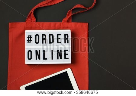 Lightbox With Words Order Online. Online Shopping Concept. Laptop With Red Cotton Shopping Bag On Bl