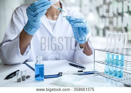 Scientist Or Medical In Lab Coat Holding Test Tube With Reagent, Mixing Reagents In Glass Flask, Gla