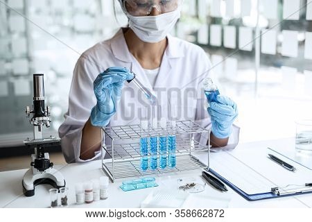 Biochemistry Laboratory Research, Scientist Or Medical In Lab Coat Holding Test Tube With Using Micr