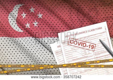 Singapore Flag And Health Insurance Claim Form With Covid-19 Stamp. Coronavirus Or 2019-ncov Virus C