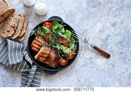 Grilled Steak With Mix Salad And Vegetables In A Pan On A Concrete Background.
