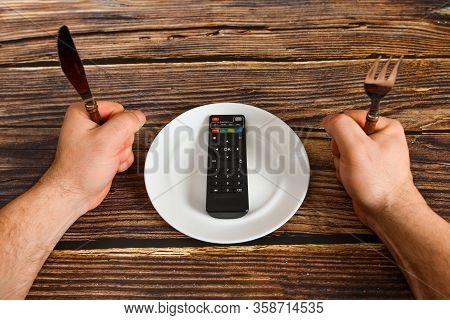 The Remote Control From The Tv Lies On A Plate, Information From The Tv Instead Of Food, The Concept
