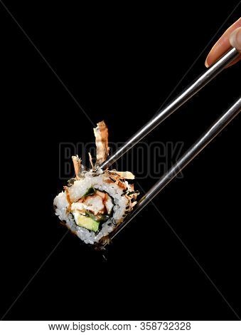 Japanese And Asian Cuisine Sushi Rollin Chinese Chopsticks With Fresh Ingredients Over Black Backgro