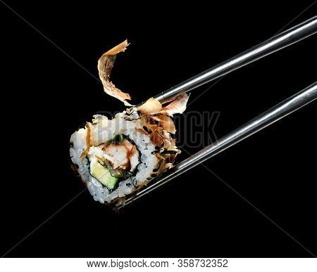 Japanese And Asian Cuisine Sushi Rollin Chinese Chopsticks With Fresh Ingredients Over Black Backgro