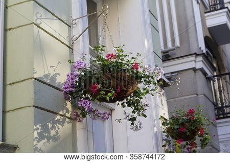 Hanging Baskets Of Flowers On The Wall Of A Building