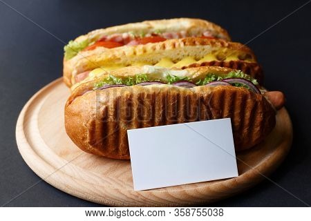Three Hot Dogs Lying On The Wooden Plate. Mock Up.
