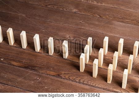 Rows Of Dominoes Standing On Wooden Table. Business Assistance And Management Concept With Wooden Bl