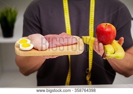 Athletic Man Holding A Board With Meat For Proper Nutrition Of The Athlete