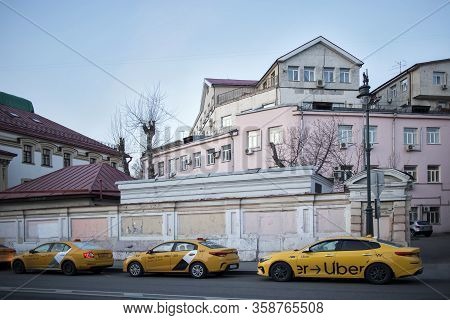 Taganka District. Old Mansions Behind The Fence. Taxi Uber Parked At The Sidewalk.