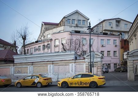 Taganka District. Old Mansions Behind The Fence. Taxi Uber Parked At The Sidewalk.