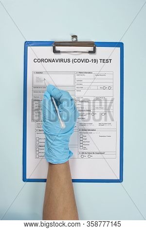 Hands Of Unrecognizable Doctor Or Nurse Filling Coronavirus Test Form. Get Covid-19 Test. Testing Fo