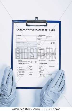 Hands Of Unrecognizable Doctor Or Nurse Filling Coronavirus Test Form. Get Covid-19 Test. Testing Fo