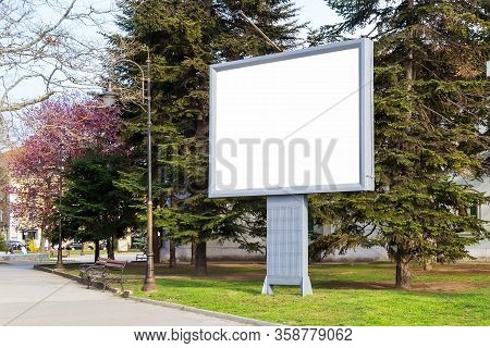 Blank Billboard Mockup With Copy Space In A Pablic Park On A Spring Day. Empty Banner For Advertisem