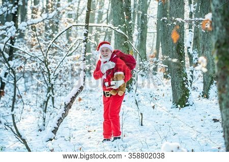Real Santa Claus In Red Cap Pulling Large Red Gift Sack. New Year Concept. Happy New Year. Wish You 