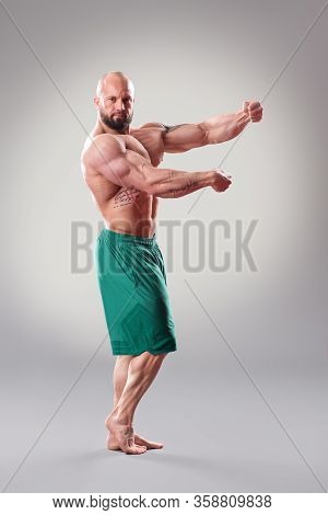 Sexy Muscular Bodybuider Posing On The Gray Background