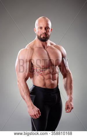 Sexy Muscular Bodybuider Posing On The Gray Background