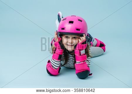 Wondeing Little Girl In Roller Skates In A Gear Lying On The Floor