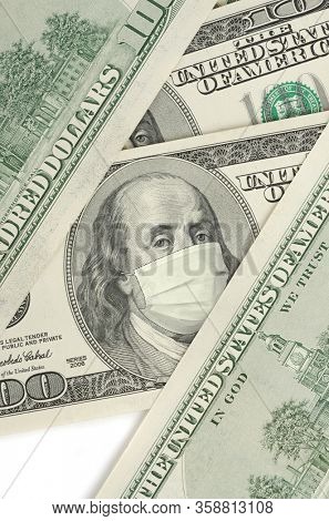 Portrait of Franklin on 100 dollar banknote with medical mask. The concept of coronavrius epidemic and the financial crisis caused by this collapse