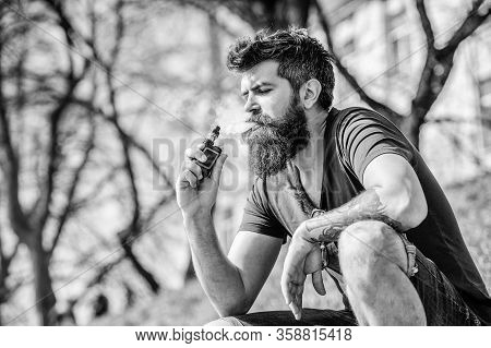 Smoking Device. Man Long Beard Relaxed With Smoking Habit. Man With Beard Breathe Out Smoke. Clouds 